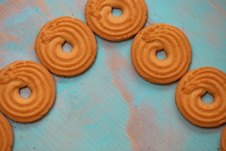 Pattern of butter cookies/biscuits on wooden teal green rustic background with space for text, flat lay design with butter cookiesの写真素材