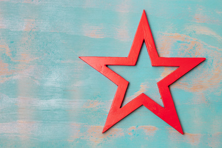 Top view of handmade wooden red star on a rustic green background with copy spaceの写真素材