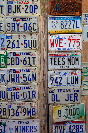 LUCKENBACH, TX - JANUARY 11, 2018 - Various old license plates displayed on a wooden wall.のeditorial素材