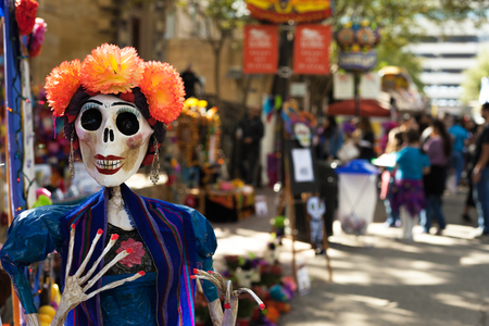 Skeleton mannequin painted and decorated with orange paper mache flowers and earrings for Dia de los Muertos/ Day of the Deadのeditorial素材