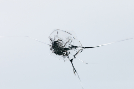Closeup  of cracked windshield with fissure lines, abstract background with copy spaceの写真素材