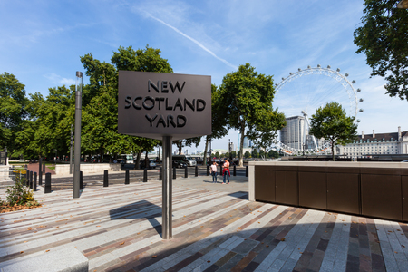 LONDON, UNITED KINGDOM - AUGUST 28, 2017 - New Scotland Yard sign with the London Eye in the background.のeditorial素材