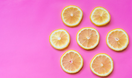 Fresh slices of leomn arranged in flower shape on pastel pink background with copy spaceの写真素材