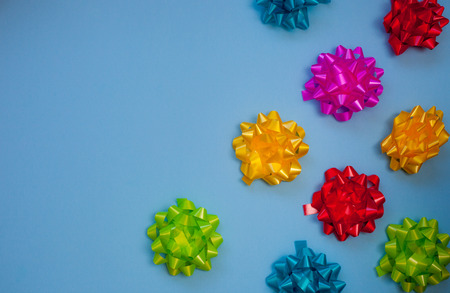 Colorful flora satin bows on pastel blue background with copy spaceの写真素材
