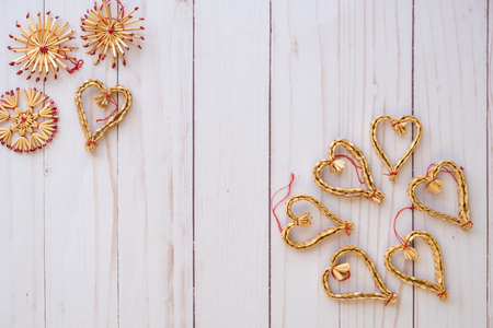 Scandinavian straw christmas ornaments flat lay on a wooden backgroundの写真素材