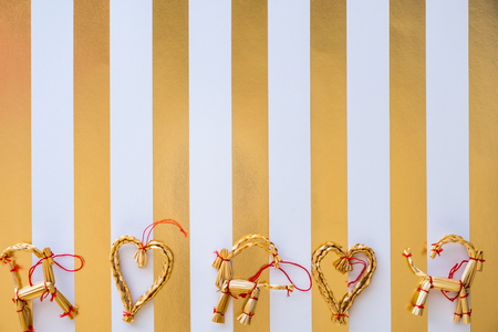 Scandinavian straw ornaments flat lay on a white and golden stripped backgroundの写真素材