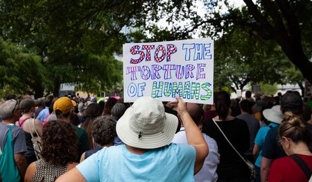 AUSTIN, TEXAS - JULY 2, 2019 - People protesting against President Donald Trump and border camps. Different demands written on pancards.のeditorial素材