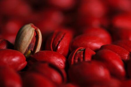 Red pistachio nuts with a single bleached nut.の写真素材