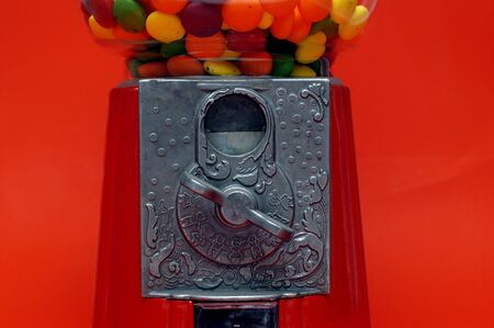 Close-up of a gumball machine against red.の写真素材