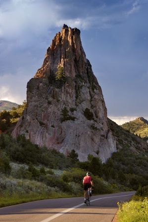 A cyclist rides past a rock formation. This could represent healthy living, freedom, adventure or any other number of things.の写真素材