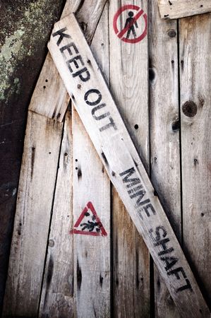 A wooden door warning people of the danger of a mine shaft, telling them to keep out.の写真素材