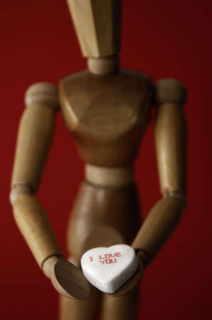 A manikin holds a white heart with the words 'I love you' on it.の写真素材