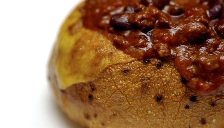 A toasted bread bowl stuffed full of chili and cheese.の写真素材