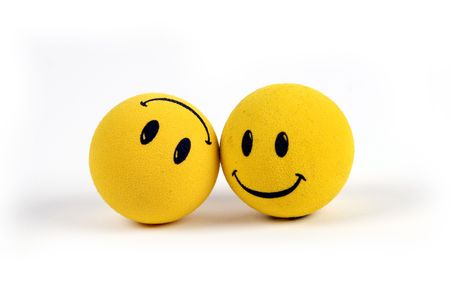 Two round smiley faces - one with a smile, one upside down with a frown.の写真素材