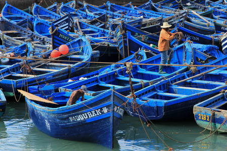Blue fishing boats on an ocean coast in Essaouira, Moroccoのeditorial素材