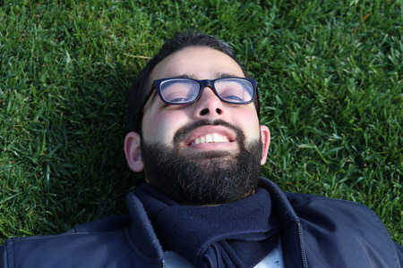 Young man smiling on grassの写真素材