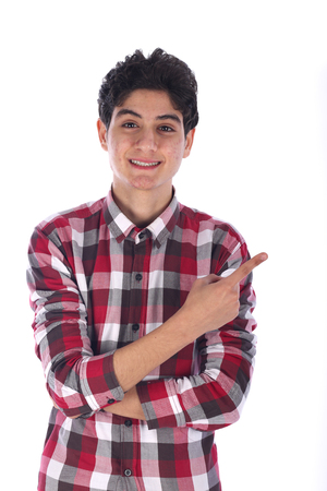 Portrait of smiley friendly teenage boy pointing up with his finger, teenager wearing red shirt,  isolated on white backgroundの写真素材
