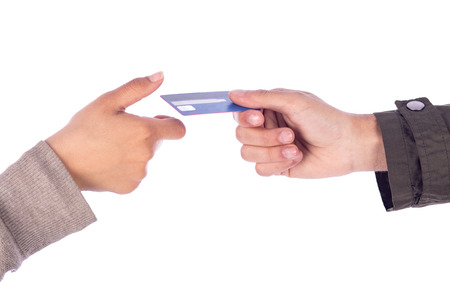 Cropped shot of a hand taking credit card from another hand, isolated on white backgroundの写真素材