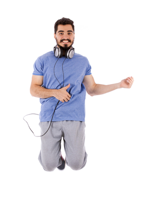 Handsome happy excited beard young man jumping and acting play guitar, guy wearing blue t-shirt, isolated on white backgroundの写真素材