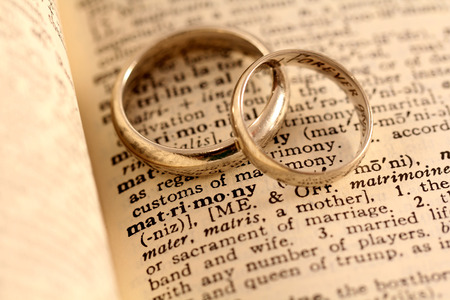 The word matrimony in the dictionary with two wedding bands atopの写真素材