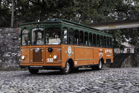A trolley is parked on the cobblestone riverfront in Savannah Georgiaのeditorial素材