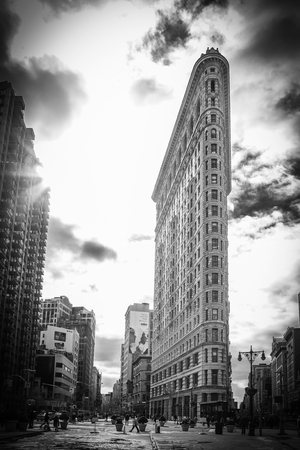 A view of New York City surrounding the famous Flatiron Building where Broadway and Fifth Avenue meet   Beautiful clouds can be seen in the sky and the morning sunlight shines through the tops of the buildings  Madison Square Park is to the left in the phのeditorial素材