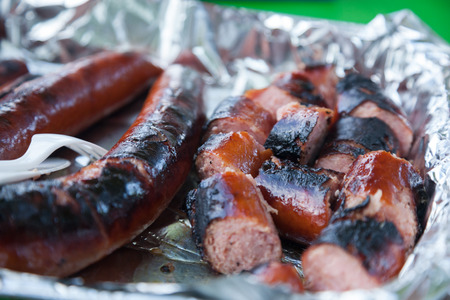 Whole and chopped hot dogs sit inside a foil pan ready to be served.の写真素材
