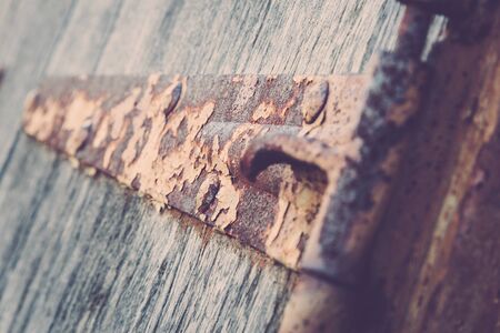 Details of an old rusty hinge on wooden shutters.の写真素材