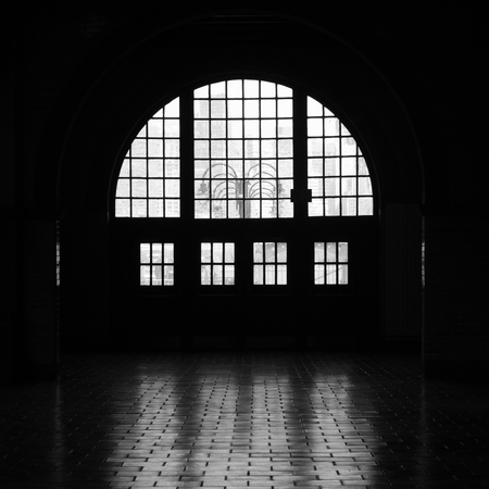Light streams through windows at the Liberty State Park railroad and ferry terminal creating a beautiful silhouette. Image is black and white.の写真素材