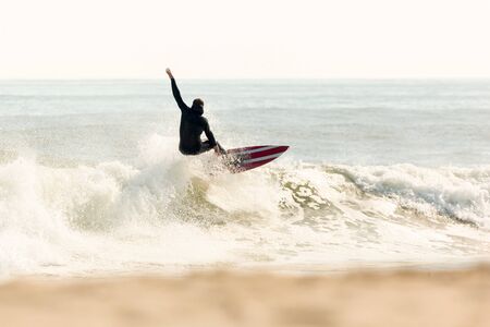 A surfer battles the waves on a beautiful sunny day.の写真素材