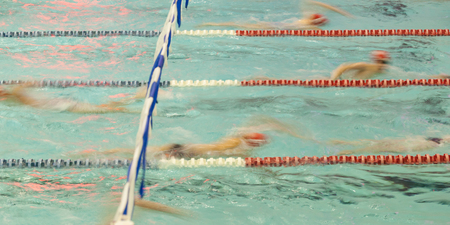 Swimmers warm up in an indoor pool. Motion Blur shows movement.の写真素材