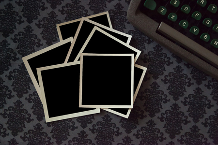 A stack of vintage photos on an ornate background with a retro typewriter in the frame. Add your own...