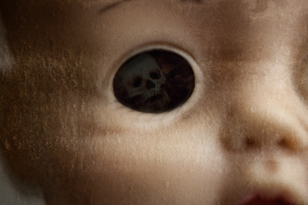 A closeup of a creepy doll's eye, with a skull where the eyeball would be.の写真素材