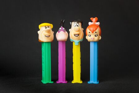 WOODBRIDGE, NEW JERSEY / UNITED STATES - January 16, 2020: Four Flintstones Pez dispensers are lined up on a black backgroundのeditorial素材