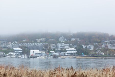 HIGHLANDS, NEW JERSEY / USA - November 5, 2017: A view of the Atlantic Highlands over the Shrewsbury River on a foggy autumn day. Photo taken from Sandy Hook. The Twin Lights lighthouses are barely visable through the fog.のeditorial素材