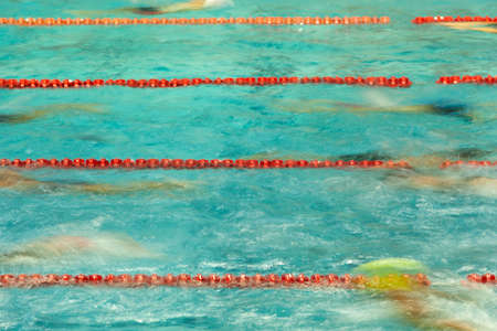Competitive swimmers warm up in a pool before racing. The image was shot using a long exposure to show motion blur.の写真素材