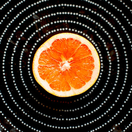 plate with half grapefruit on the kitchen countertopの写真素材