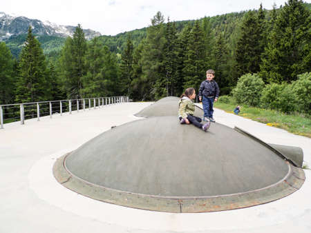 Italy, Lombardy, Bormio, children play over fort domes of the First World War. Forte Venini, on the Italian Alps on the border with Switzerlandの写真素材