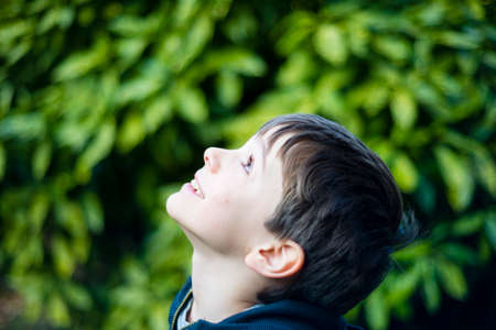 portrait of 7 year old boy outdoor in the garden in winterの写真素材