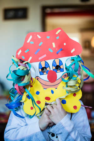 portrait of a 6 year old boy with a carnival mask made by himself at homeの写真素材