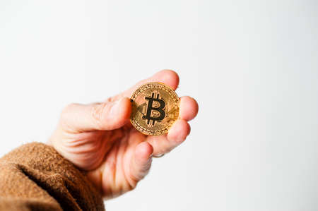 bitcoin electronic coin holding in the hand white backgroundの写真素材