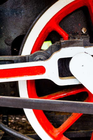 red and white wheel of an old historic steam train on rail