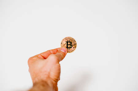 bitcoin electronic coin holding in the hand white backgroundの写真素材