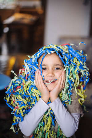 child little girl with streamers around his neck and head for the carnival party in his home