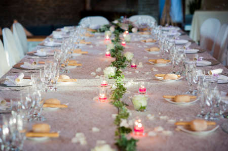 restaurant table prepared for a wedding party with elegant cutlery and crockeryの写真素材