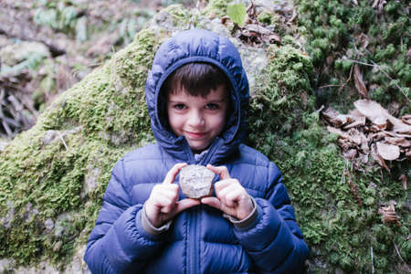 portrait of a child showing a stone in his handsの写真素材