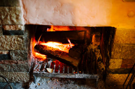 fireplace with wood burning red embers close up viewの写真素材