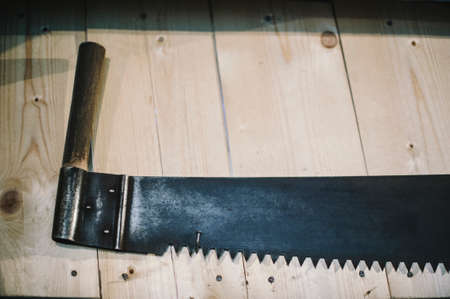woodworking workshop, old hand saw hanging on wooden wall, close up viewの写真素材