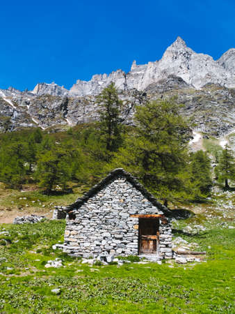 mountain hut landscape view in the spectacular angles of the devero alp on a sunny day, Lepontine Alps, summer mountain landscapeの写真素材