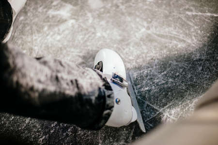legs with skates on ice close up view, on night trackの写真素材